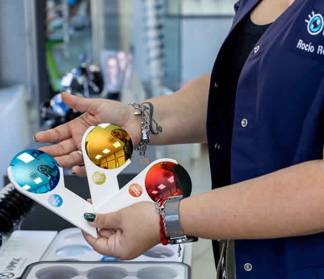 manos de óptico sosteniendo 3 tipos de colores de critales